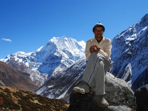 Local man sitting in the Himalayan landscape of the Manaslu region of Nepal